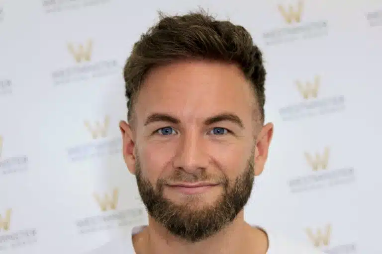 Frontal view of a bearded male patient with short styled hair demonstrating post-transplant results